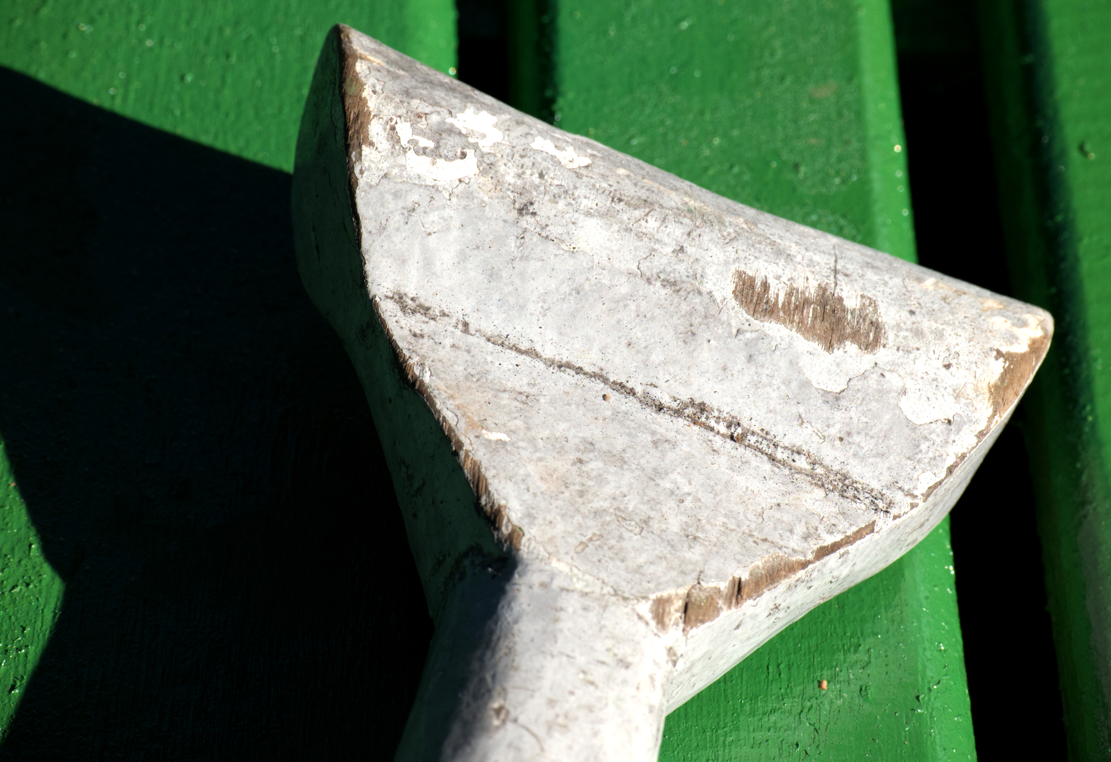 A painted oar, chipped from use, rests within reach. Motors handle most of the work on the main channel, but in shallower areas where depth can change dramatically over just a few meters, a paddle offers more precise control. The paint is worn down where the hand grips it, and where it makes contact with the water.