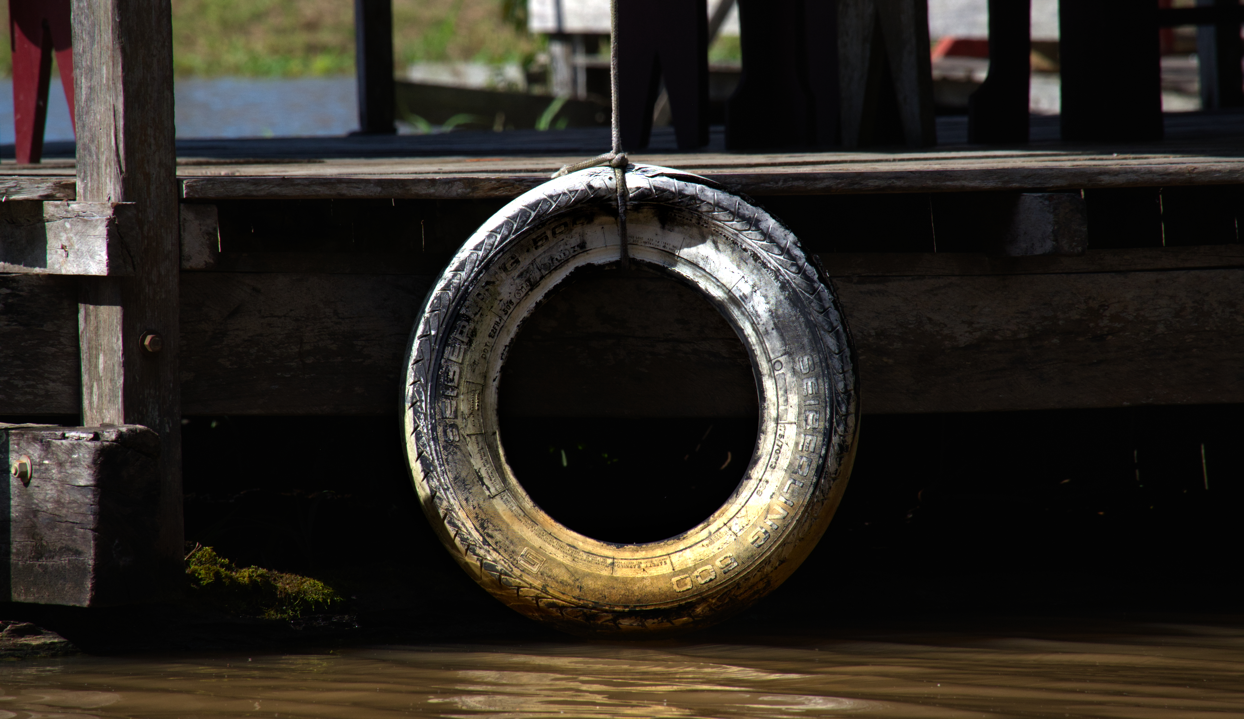 Rubber tires are fixed to the sides of boats as buffers, positioned at points of frequent contact. As smaller canoes approach larger vessels, these surfaces compress and absorb impact, reducing damage from repeated collisions. In sediment-heavy water, where visibility is low and movement is constant, these additions function as a simple but effective interface between materials.